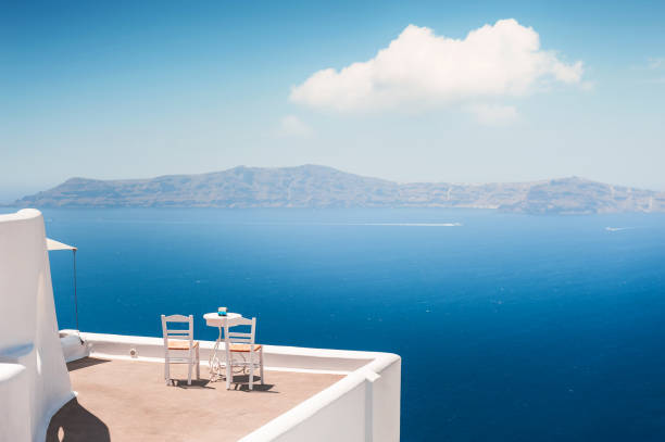 biała architektura na wyspie santorini w grecji. dwa krzesła na tarasie z widokiem na morze. - fira zdjęcia i obrazy z banku zdjęć