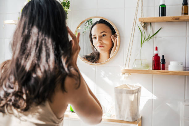 Beautiful hispanic woman looking in the mirror