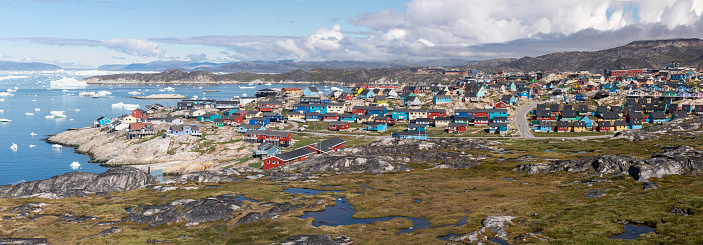 Greenland view of colorful houses in Ilulissat City and icefjord. Tourist destination in the arctic. Panoramic photo of typical Greenland village houses.  Rodebay