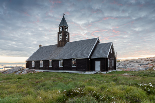 Greenland Ilulissat Zion Church in sunset with flowers.\nmidnight sun, Greenland