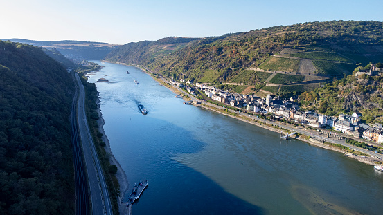 Industrial ships on Rhine river in the Rhine valley. Visible rocks and sandbars due to extraordinary low water level after a long period of drought in 2022.