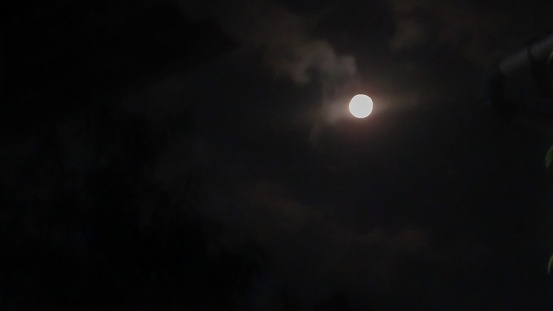 the moon among the white clouds in the dark night