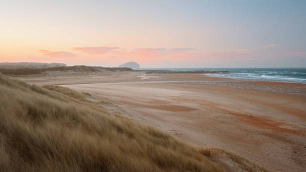 istock Seashore and rocky island landscape with lighthouse and sunset sky 1413872693