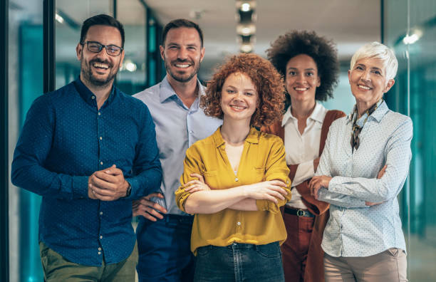 Business team portrait Portrait of Modern multi ethnic business team standing and looking at camera organised group photo stock pictures, royalty-free photos & images