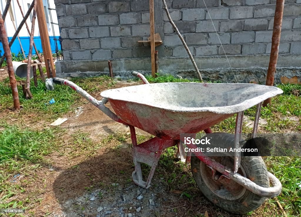 red sand cart on background of unfinished building, construction work, building sand cart, hard worker. Agriculture Stock Photo