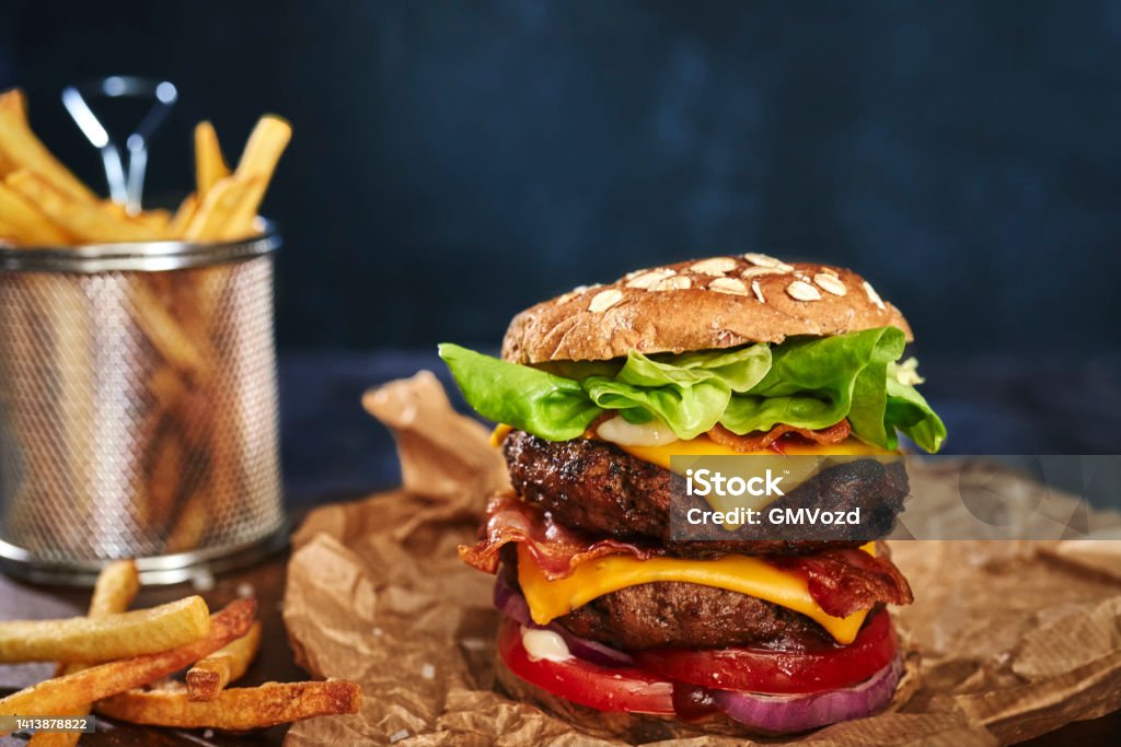 Double Beef Burger with Tomato, Cheese, Bacon, Onions and Lettuce American Culture Stock Photo