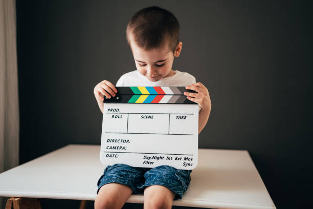istock Little boy having fun with a movie clapperboard 1413879821