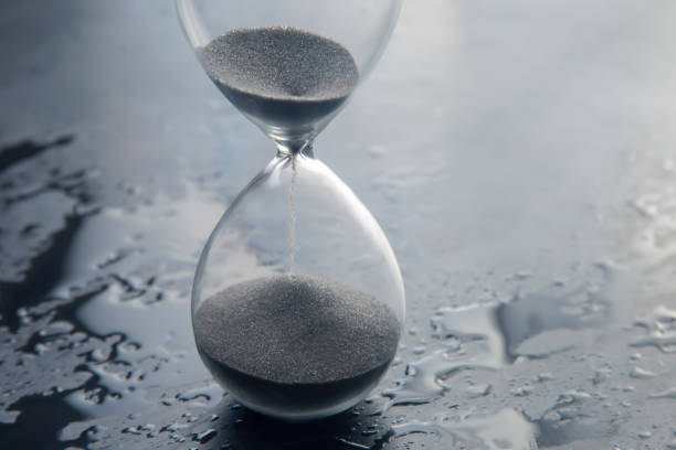 istock Hourglass on a light background. Time is money. Business solutions in time. 1413880219