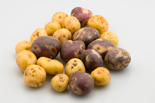 heap of fresh raw potato isolated on white background