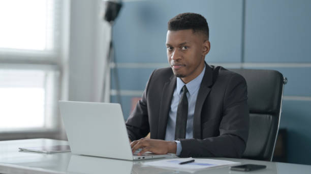istock African Businessman Shaking Head as No Sign while using Laptop in Office 1413883632