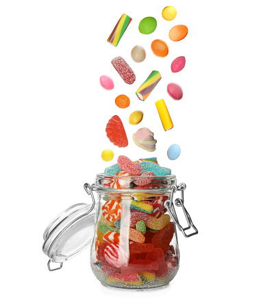 Top view of an open candy jar filled with multi colored candies and jelly beans lying down on white background. Some candies are spilled out of the jar directly on the background. DSRL studio photo taken with Canon EOS 5D Mk II and Canon EF 100mm f/2.8L Macro IS USM