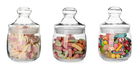 Still life of a variety of candy jars filled with colorful confections.