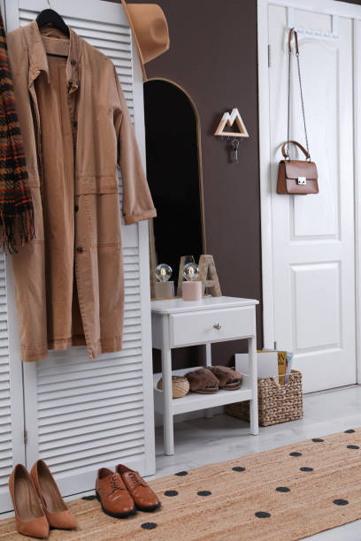 intérieur de couloir moderne avec des meubles blancs élégants et un cintre en bois pour les clés sur le mur brun - nobody brown matrial shoe cupboard photos et images de collection