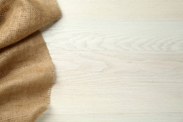 istock Natural burlap fabric on white wooden table, top view. Space for text 1413883934
