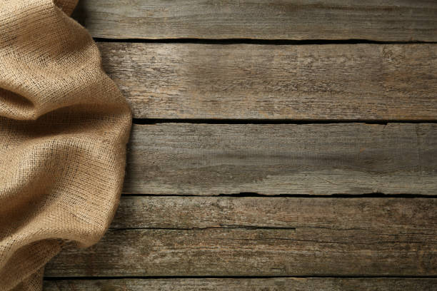 istock Natural burlap fabric on wooden table, top view. Space for text 1413884096