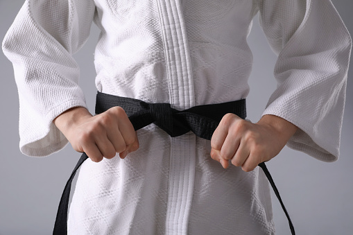 Karate black belt get tied. 