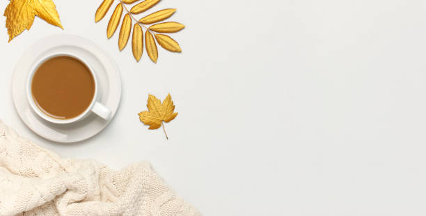 istock White cup with coffee, golden autumn leaves, knitted plaid on light background top view flat lay. Composition with cup of morning coffee, hot autumn drink Fall concept Autumn background Cozy breakfast 1413886183