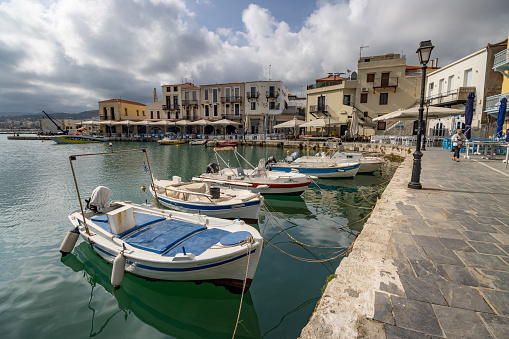 Old Port at Rethymnon Town in Crete, Greece, with people and boat identifiers visible.