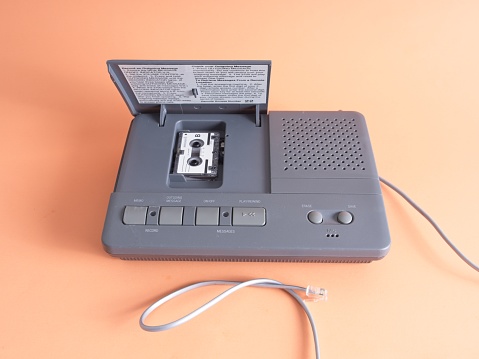 Vintage phone answering machine using a micro audio cassette with cable to an analog phone jack. Old school voice mail well before the age of smart phones and digital audio using analog recordings. To retrieve messages once you got home, you pressed a button to check for messages.