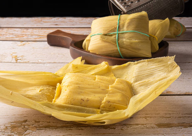 istock Pamonha, corn-based Brazilian food, arranged on a rustic wooden table, selective focus. 1413889758