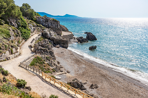 Famous and long Akti Miaouli sandy beach with sidewalk, located in the hotels area, on the western side of the island of Rhodes Island, Greece.