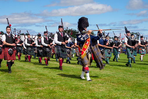 Keith, Scotland, UK - August 07, 2022: Massed Pipe Bands at the Keith County Show in Moray, Scotland. Massed pipe bands, where a number of smaller pipe bands march together playing traditional tunes on bagpipes and drums, are a feature of various events held in Scotland during the summer, and are a part of Scottish culture.