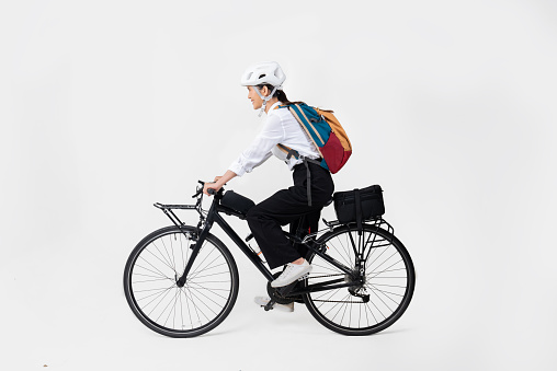 Asian beautiful woman, she is riding a city bike to work.She is greeting.studio concept