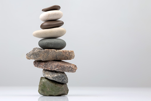 Three stones stacked on a bed of algae overlooking the rocky bay.