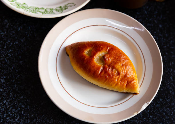 istock Ruddy pie with filling on white plate. Russian cuisine 1413898232