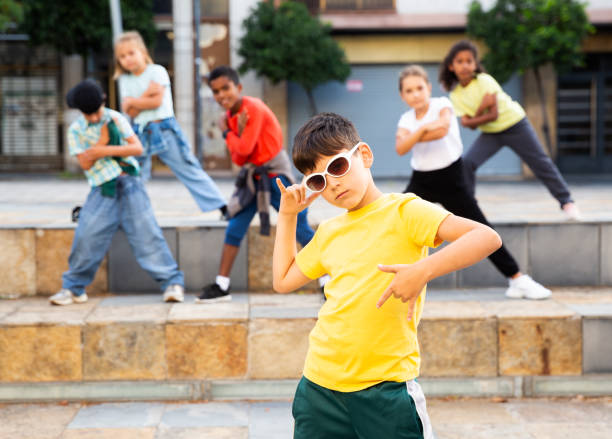 istock Tween boy hip hop dancer performing with group on city street 1413899080