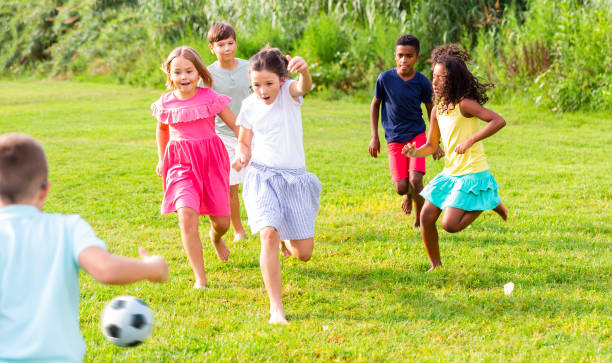 istock Cheerful tween friends playing with ball outdoors in summer 1413899138