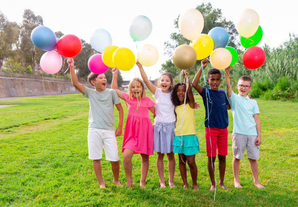 istock Barefoot kids playing with balloons on grass 1413899140
