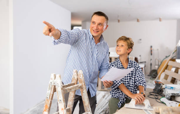 istock Man showing son blueprints in new home 1413899359