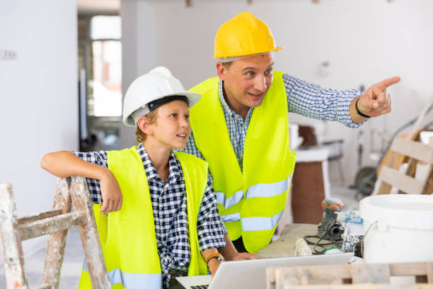istock Young boy and his father discussing work plan in new apartment 1413899365