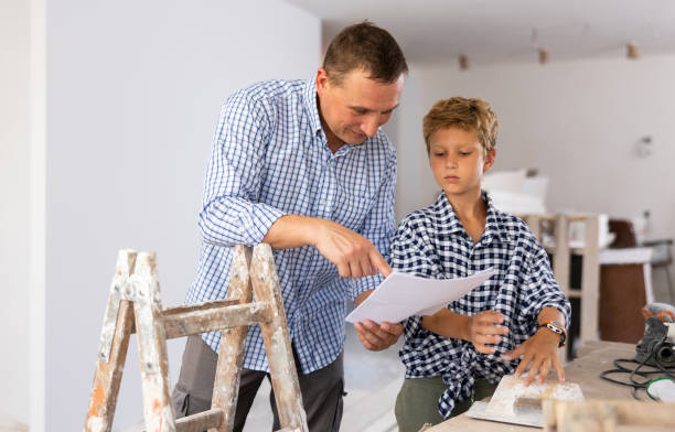 istock Man showing son blueprints in new home 1413899375