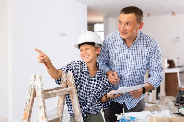 istock Man showing son blueprints in new home 1413899378