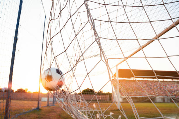istock Soccer ball going into the net, motion blur on ball,  full stands 1413901022