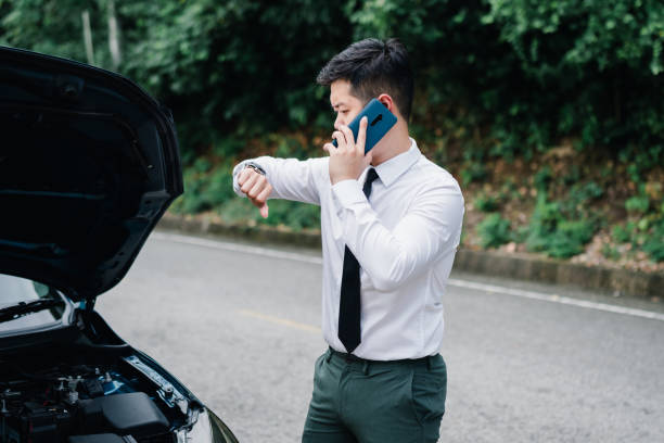 istock Asian businessman broken car engine breakdown his use mobile calling insurance smartphone problem, Accident emergency on the road concept. 1413902549