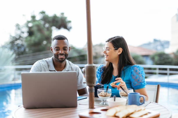istock Couple using laptop/cellphone during breakfast outdoors 1413906570