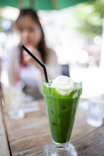 Maccha float and a woman in outdoor cafe