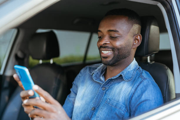 homem usando smartphone no carro - cheerful savings men one person - fotografias e filmes do acervo