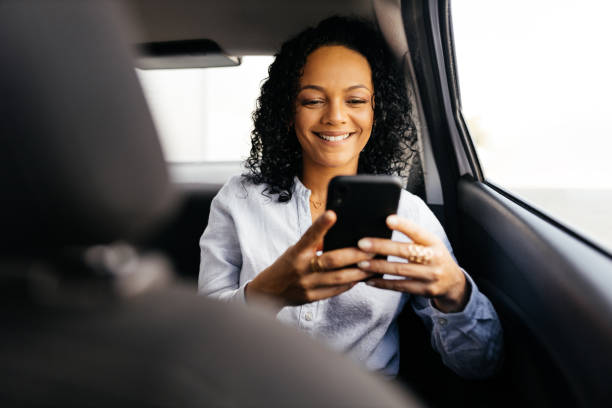 istock Businesswoman using smartphone in the car 1413907508