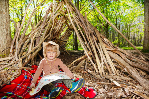 istock Boy in boy-scout hat sit with treasury map playing treasure 1413908190