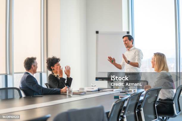 A Mature Businessman Giving A Presentation To Coworkers In The Meeting Room Stock Photo - Download Image Now