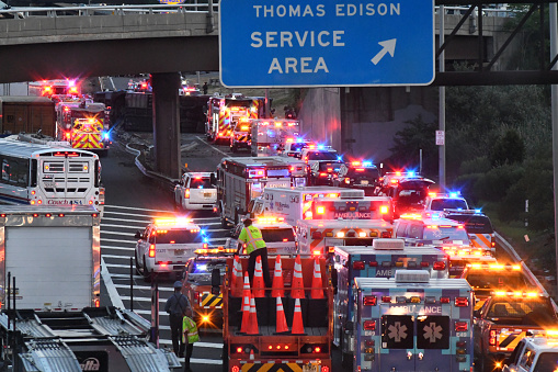 Woodbridge, NJ/US- August 9, 2022: A commuter bus traveling on the New Jersey turnpike southbound side flips and crashes into near an overpass in the Woodbridge area triggering a mass casuality event and response from all neighboring law enforcement and EMS vehicles.