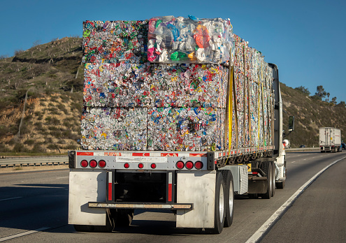 Truck with aluminum cans for recycling traveling down a road