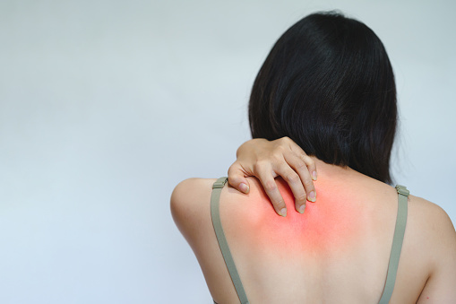 A woman has itching on her back because she is allergic to something.