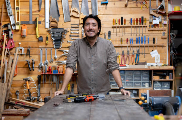 istock Happy man working on a project at his home workshop 1413927198