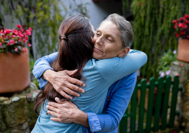 istock Loving mother hugging her daughter while she is paying a visit at home 1413927242