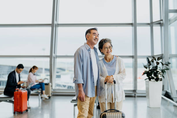 sorridentes turistas de casal sênior asiático no aeroporto - pre flight - fotografias e filmes do acervo